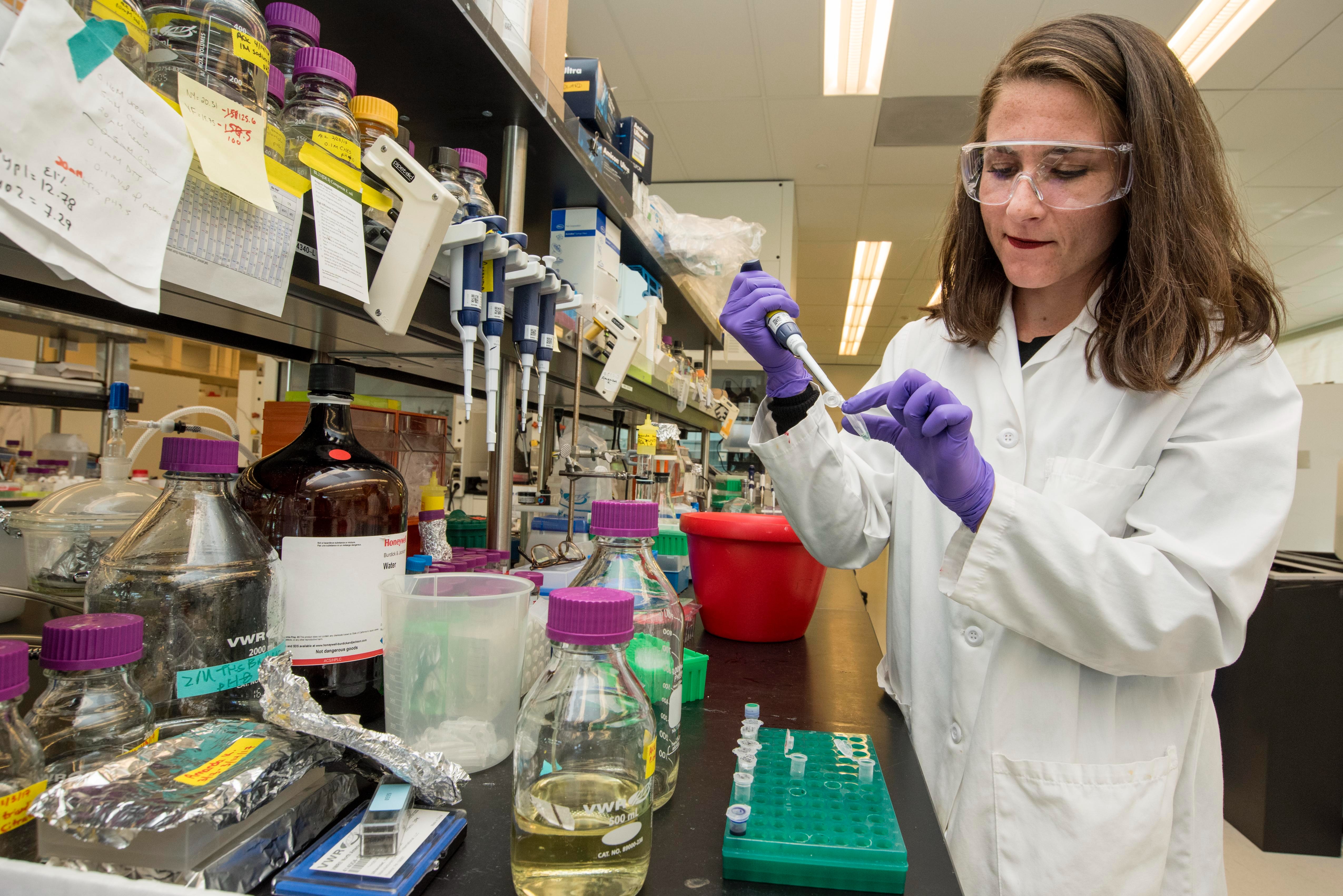 scientist in lab with purple gloves